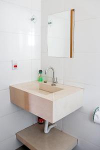 uma casa de banho com um lavatório e um espelho em Pousada - Pesqueiro do Brasinha 