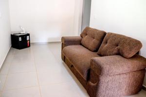 um sofá castanho sentado numa sala de estar em Pousada - Pesqueiro do Brasinha 