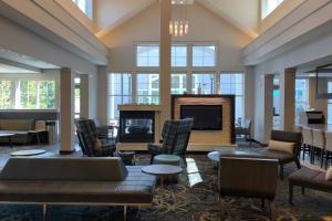 a lobby with a fireplace and chairs and a tv at Residence Inn Concord in Concord
