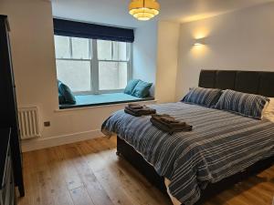 a bedroom with a large bed with a window at Spacious, modern 2-bedroom flat in Clifton in Bristol
