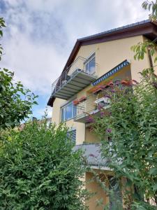 a yellow building with balconies and plants at R7 Bodensee mit Seesicht sonnig ruhig groß in Uhldingen-Mühlhofen