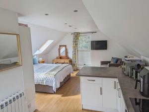 a bedroom with a bed and a living room at Badgers Den in Linlithgow