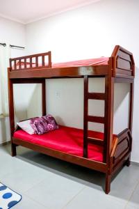 a bunk bed with a red mattress and a ladder at Pousada - Pesqueiro do Brasinha 