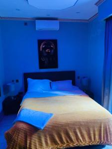 Habitación azul con cama con una foto en la pared en Ultimate Escape, en Lusaka