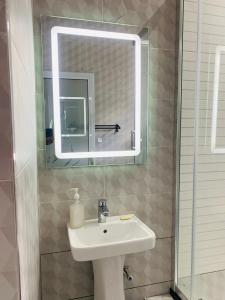 ein Bad mit einem Waschbecken und einem Spiegel in der Unterkunft Ultimate Escape in Lusaka