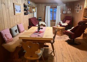 uma sala de estar com uma mesa de madeira e cadeiras em Augustin Oswald em Müstair