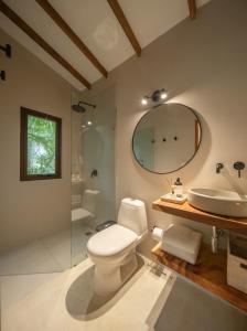 a bathroom with a toilet and a sink and a mirror at ICACO refugio de playa in Guachaca