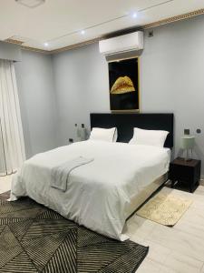 1 dormitorio con 1 cama blanca grande y 1 alfombra en Ultimate Escape, en Lusaka