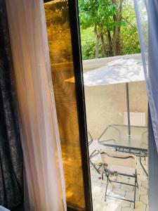 vistas a un patio con mesa y sillas a través de una ventana en Ultimate Escape, en Lusaka