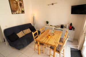 ein Wohnzimmer mit einem Holztisch und einem Sofa in der Unterkunft Vias-Plage - Villa climatisée à 600m de la plage in Vias