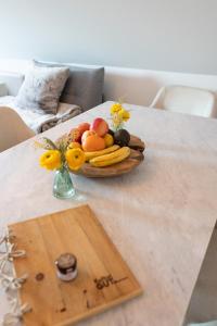 einen Obstteller auf einem Tisch mit einer Blumenvase in der Unterkunft Sope Skylodge 09 - Donjeta's Vogelsang - Oberried, Schauinsland in Oberried