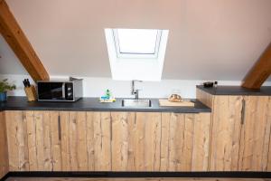 eine Küche mit einer Spüle und einer Mikrowelle in der Unterkunft Sope Skylodge 09 - Donjeta's Vogelsang - Oberried, Schauinsland in Oberried