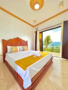 een slaapkamer met een groot bed en een groot raam bij Mabini Sky View Resort in Cebu City