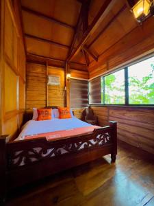 1 dormitorio con 1 cama en una habitación de madera en Mabini Sky View Resort, en Cebú