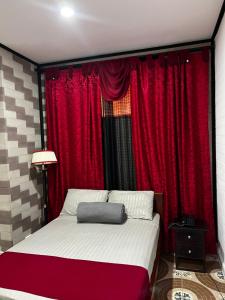 1 dormitorio con cortinas rojas y 1 cama grande en HOTEL PARADISE RIONEGRO en Rionegro