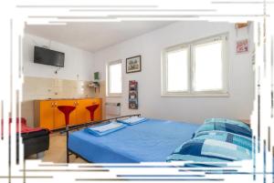 a bedroom with a blue bed and a tv at Hostel Oktarin in Kaštela