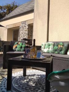 een tafel met een fles wijn op een patio bij Gîte de la Cuve in Huisnes-sur-Mer