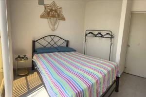 a bedroom with a bed with a colorful striped comforter at Departamento en Punta Diamante Acapulco in Barra Vieja +17 photos