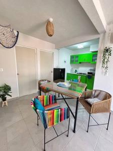 a kitchen with a table and chairs and green cabinets at Departamento en Punta Diamante Acapulco in Barra Vieja