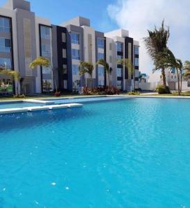 a large blue swimming pool in front of a building at Departamento en Punta Diamante Acapulco in Barra Vieja