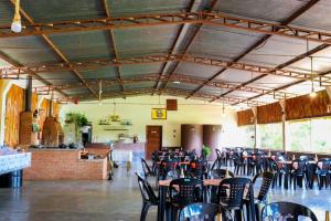 a large room with tables and chairs in it at Pousada - Pesqueiro do Brasinha 