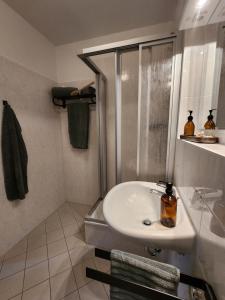 y baño blanco con lavabo y ducha. en Hotel zur Post, en Wernigerode