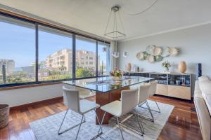 ein Esszimmer mit einem Glastisch und weißen Stühlen in der Unterkunft Blue House by the Beach in Leça da Palmeira