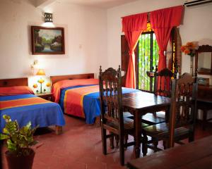 a bedroom with two beds and a table and chairs at Hotel Azteca in Puerto Vallarta
