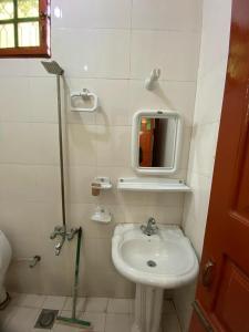 a small bathroom with a sink and a mirror at Zain Hotel Abbottabad in Abbottabad