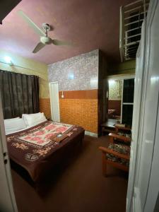 a bedroom with a bed and a ceiling fan at Zain Hotel Abbottabad in Abbottabad