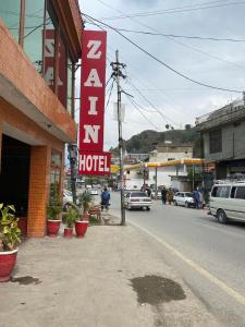 a hotel sign on the side of a street at Zain Hotel Abbottabad in Abbottabad