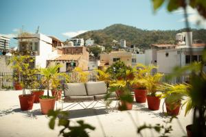 a chair sitting on a balcony with potted plants at Hotel Azteca in Puerto Vallarta +19 photos