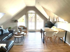 a living room with a table and a couch at Penthouse Sonnenuhr in Zingst