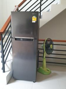 a refrigerator next to a staircase with a fan at House in community mall, spacious 6 people, 3BR in Chiang Mai