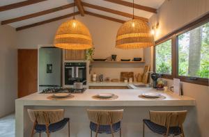 a kitchen with two chandeliers and a large island at ICACO refugio de playa in Guachaca