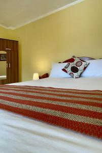 um quarto com uma cama com lençóis brancos e almofadas em Hostal Restaurant Gocta em Cocachimba