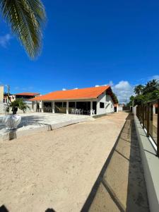 un bâtiment avec un toit orange sur une plage dans l'établissement Casa à Beira-mar de Peroba, à Peroba