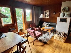 a living room with a table and chairs and a fireplace at Ferienhaus Ahorn, 3 Schlafzimmer, Todtnauberg in Todtnauberg