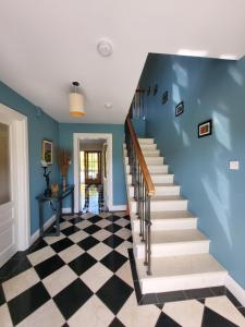 uma escada numa casa com paredes azuis e um piso xadrez em Reeks Country House em Killarney