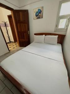 duże białe łóżko w pokoju z oknem w obiekcie Golf hills w mieście Jaunde