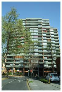 un edificio de apartamentos alto con una señal de stop delante de él en Andes Suite Home Ebro, en Santiago
