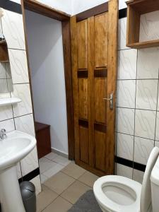 bagno con servizi igienici e porta in legno di Golf hills a Yaoundé