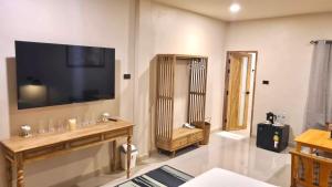a living room with a television on the wall at VNL Stay in Trang