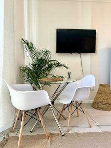 uma sala de jantar com duas cadeiras brancas e uma mesa em CBD Studio Apartment em Windhoek