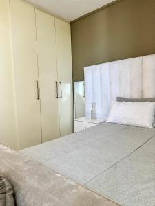 um quarto com uma cama grande e armários brancos em CBD Studio Apartment em Windhoek