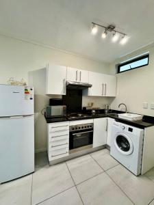 uma cozinha com um frigorífico branco e uma máquina de lavar louça em CBD Studio Apartment em Windhoek