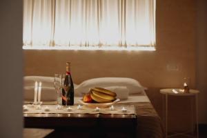 a table with a plate of bananas and a bottle of wine at San Michele Luxury Rooms in Matera