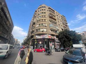 une rue urbaine animée avec des voitures et un grand bâtiment dans l'établissement Luxury apartment Downtown Cairo, au Caire