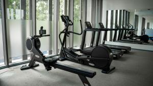 a gym with several tread machines in a room with windows at Luxury Studio @Lennox Apartment Airport Accra in Accra