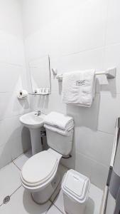 a white bathroom with a toilet and a sink at Samaná in Tacna